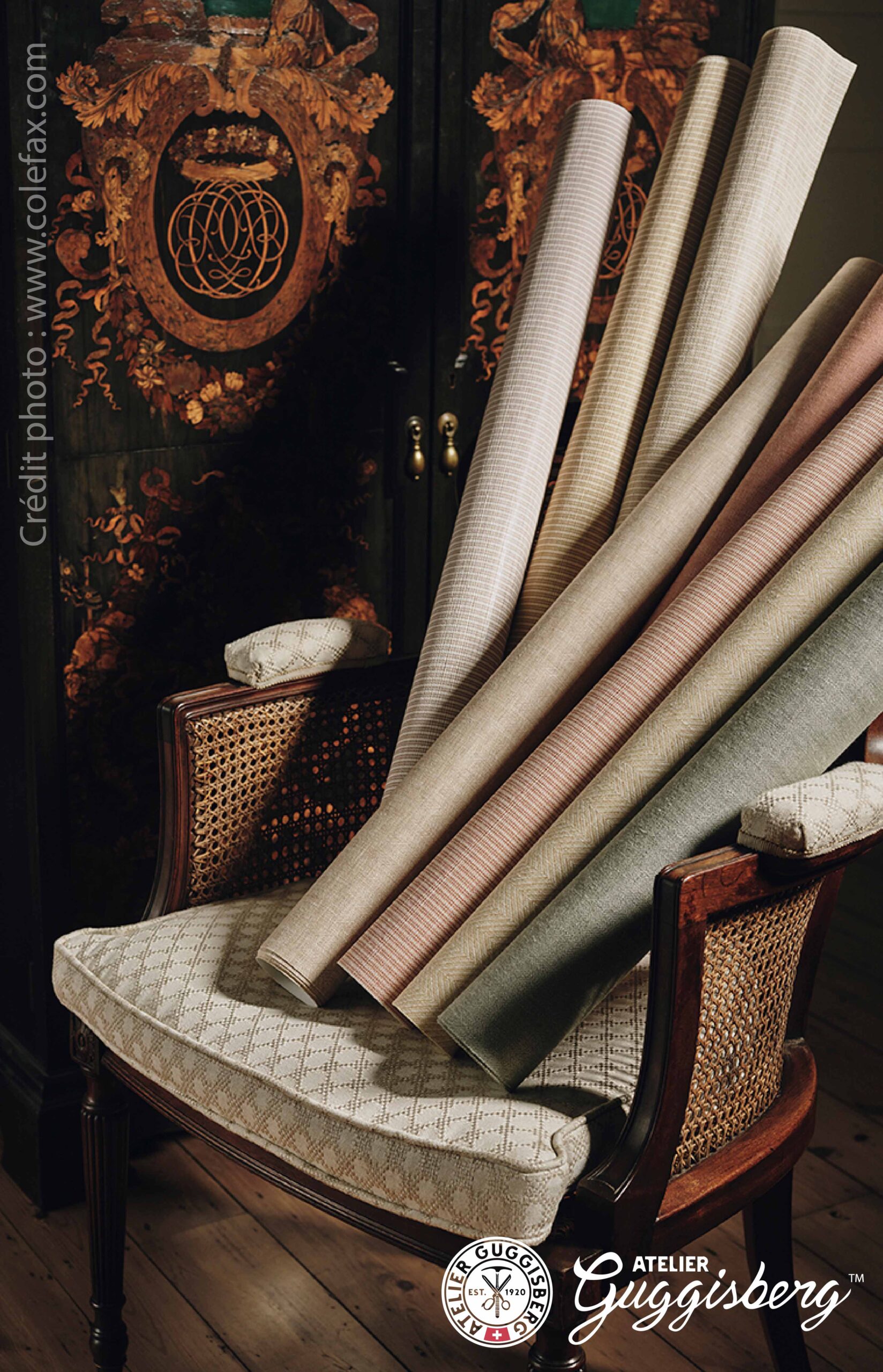 Rouleaux de tissus d'ameublement Colefax posés sur un fauteuil ancien cannelé